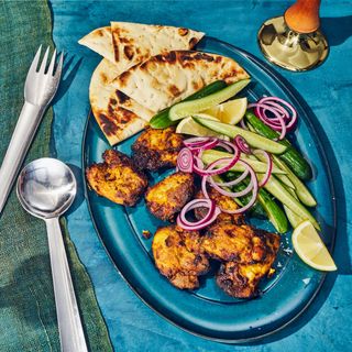 Air fryer chickn tikka on a platter with vegetables and naan