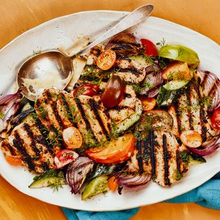 A heaping plate of grilled chicken interspersed with a range of colorful vegetables.